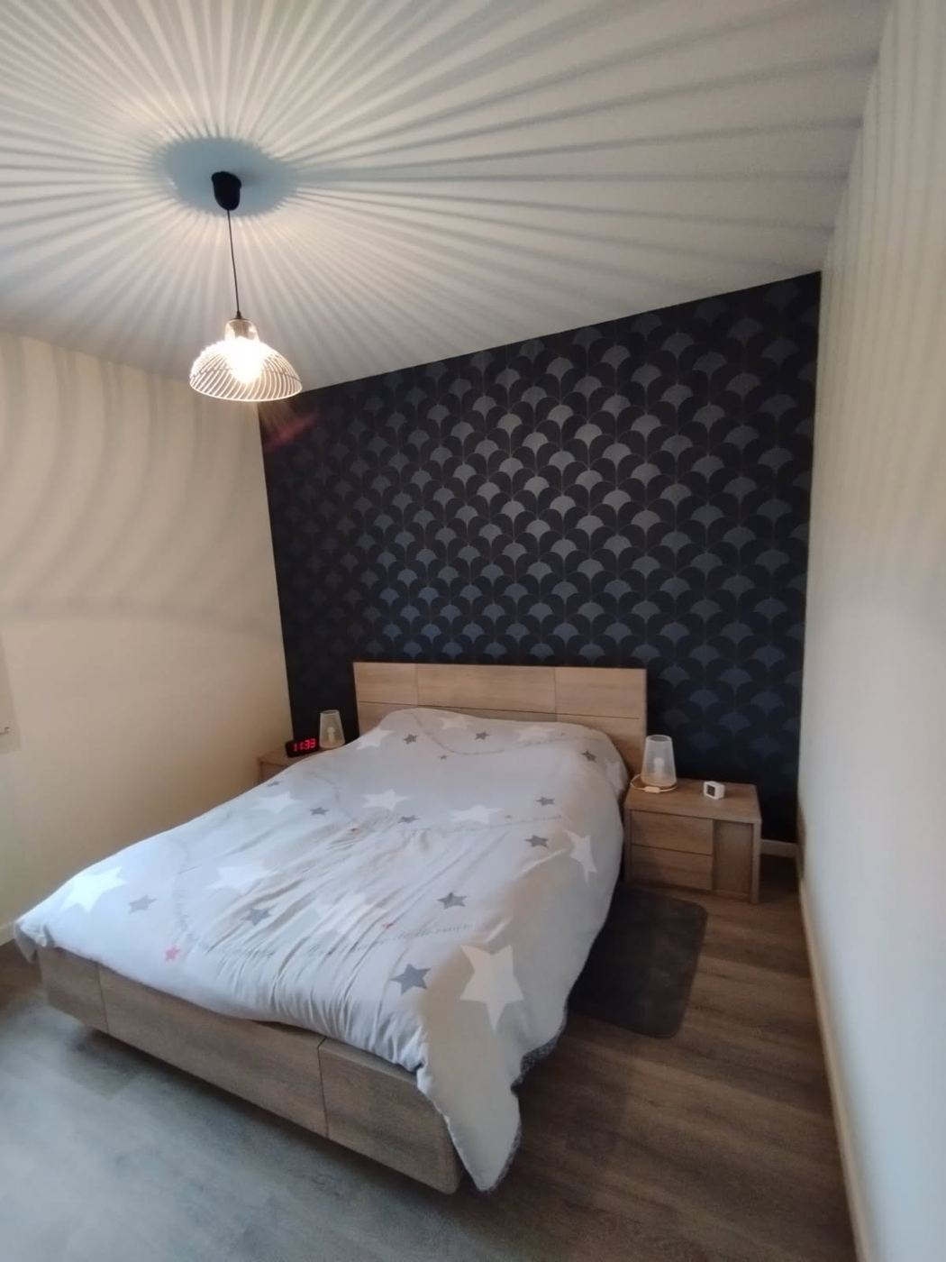 Chambre rénovée par Nouvel Espace — tête de lit habillée de papier peint graphique